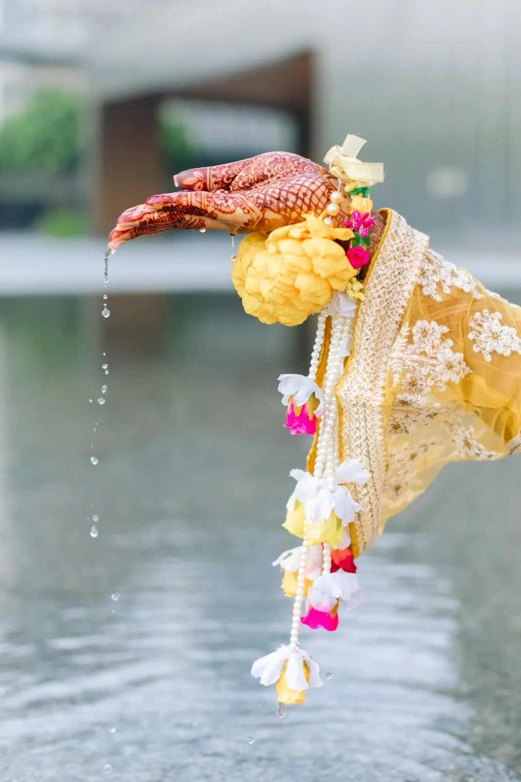 Yellow and orange flower tassel ornament hanging above water
