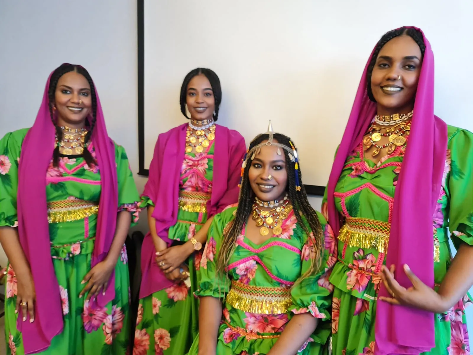 Collage of two photos showing three women in bright green and pink outfits with matching pink headscarves