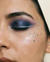 AI-generated reference for the Glitter galaxy idea: a blue and violet smoky eye with a silver liner and small silver stars on the cheekbone